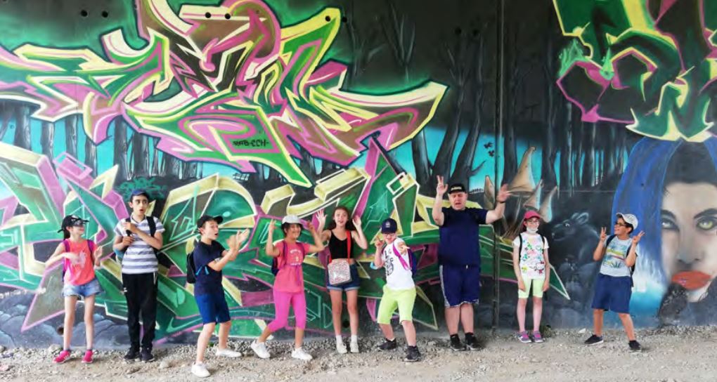 Fresque en graffitis artistiques, avec une bande d'enfants au premier plan