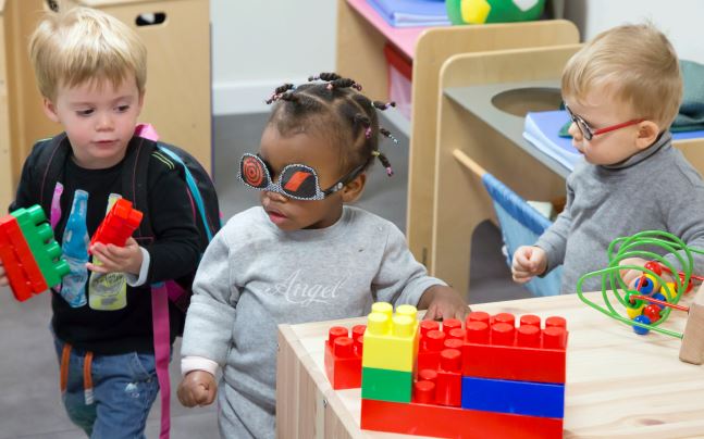 Trois jeunes enfants jouent à des jeux de construction